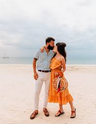 Young couple lying on the beach holding hands near the surf. Couples Resorts Negril Jamaica Beach Vacation Beachfashion Travel Couplesstyle Couples Resorts Florida Vacation Outfits Beach Vacation Outfits