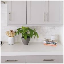 A blue minimalist kitchen with a grey marble backsplash and a black dining set for a gorgeous look. 6 Gray Shades For A Kitchen That Are Surprising Big Chill