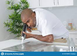 man applying silicone around kitchen
