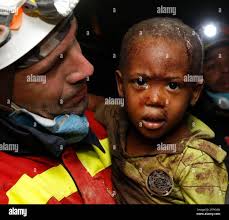 A Spanish rescuer carries two-year-old Redjeson Hausteen Claude after he  was rescued from a collapsed home in the aftermath of the earthquake in  Port-au-Prince, Thursday, Jan. 14, 2010. (AP Photo/Gerald Herbert Stock