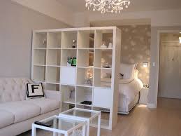 How can i use bookcases as a room divider safely in earthquake country? 25 Creative Ideas For Using Bookshelves As Room Dividers Small Apartment Decorating Apartment Room White Studio Apartment
