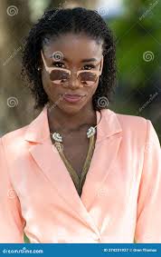 Headshot of a Young Beautiful Woman Looking Back at the Camera Over Her  Glasses Stock Image