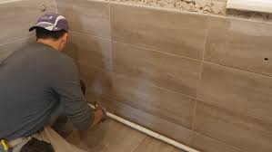 However, you can place porcelain tiles or ceramic tiles on your walls. Man Putting Seams Of Beige Stock Video 100 Royaltyfri 33004726 Shutterstock