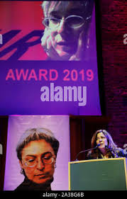 London, UK. 4 October 2018. Anna Wigley, an IWM staff member, poses next to  "Weeping Window", the iconic poppy sculpture by artist Paul Cummins and  designer Tom Piper which has been unveiled