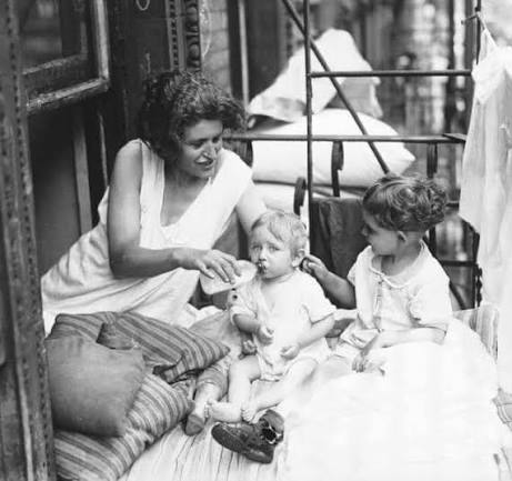 Heartbreaking 1930s photo of a mother protecting her sons on a NYC fire  escape