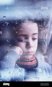 Little girl at a rainy window hi-res stock photography and images