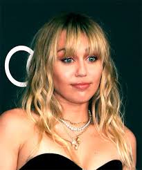 If you have long tresses and wear sleek hairstyles a pony like this is the classiest choice that is timeless. Miley Cyrus Medium Wavy Blonde Hairstyle With Blunt Cut Bangs