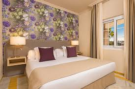 The balcony suite includes a private outdoor terrace seating area with sweeping water views. Junior Suite La Cala Resort
