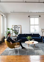 Grey and yellow living room with yellow custom furniture. Modern Loft Living Room With Navy Blue Sofa White Painted Brick And Mustard Yellow Chair Hgtv