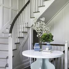 White and wood dining room with stairs and poster. Curved Staircase Wall Table Design Ideas