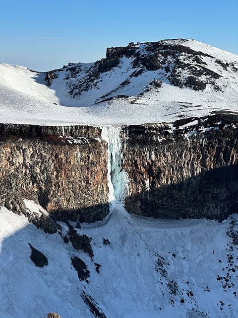 雪と氷に覆われた冬季の富士山（AI 生成）