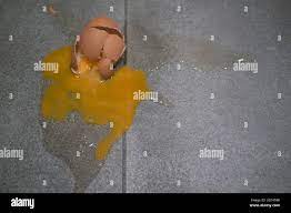 Smashed egg on grey tile floor with cracked and broken shell, egg yolk and  albumen splatter Stock Photo - Alamy