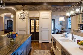 Colorful tiles inspired the blue of the cabinetry as well as the yellow kitchen cabinets in dusty blue have a softening effect in a kitchen. Large White Kitchen With Blue Island Crystal Cabinets