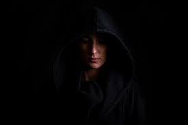 Young woman in a black hood on a dark black background. | Premium Photo