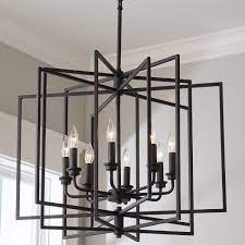 It showcases an open, geometric lantern shape, finished in a neutral black hue for a transitional look that blends in with a variety of color schemes. Abner Chandelier Large In 2021 Entryway Light Fixtures Black Chandelier Dining Room Modern Black Chandeliers