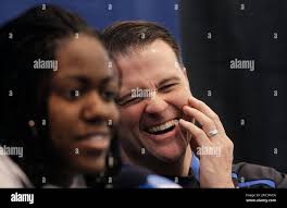 Kentucky head coach Matthew Mitchell laughs as Kentucky's Victoria Dunlap,  left, talks about attending a basketball camp run by North Carolina head  coach Sylvia Hatchell, during a news conference about their second