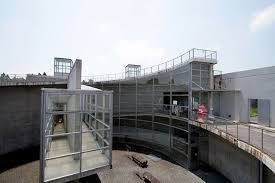 ando於古墳林立的熊本設計了一座環境博物館他希望遊客於山下停車場下車後穿越樹林來到博物館入口的水 瀑牆目前已經沒放水了再經過戶外大階段拾級而上來到屋頂先俯瞰外部多處古墳再經由象徵與歷史對話的逆時鐘大斜坡時光倒流的回到過去最後鑽到博物館 photo and video