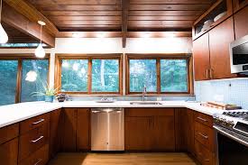 A touch of tropical vibe, this kitchen has hues of yellow and green, white cabinets, white drawers, kitchen island, and two sinks. Mid Century Modern Kitchen Sink Novocom Top