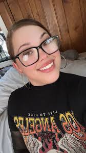 Can someone edit my photo to change my top to a black blazer and background  to a corporate office space?