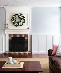 Living room boasts brown shelves next to a white beveled fireplace and a white accent chair. How To Build Fireplace Built Ins From Ikea Bookcases