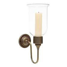 Antique, well crafted, mirrored wall sconce featuring a curved reflective background and a shiny metal candle holder at the bottom. Hurricane Candle Light Wall Lights Jim Lawrence
