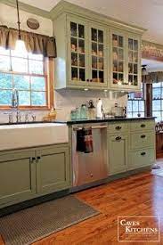This dark green kitchen uses copper worktops and backsplash to achieve a moody, modern look. Sage Green Country Cottage Kitchen With Farmhouse Sink Transitional Kitchen Other M Country Cottage Kitchen Farmhouse Sink Kitchen Green Kitchen Cabinets