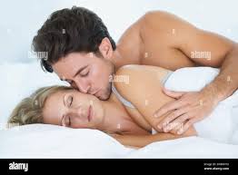 Uomo, bacio o donna che dorme nel letto per stanchezza, pace o sognare di  rilassarsi in vacanza. Coppia, amore romantico o moglie stanca in pausa  Foto stock - Alamy