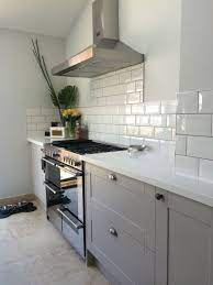 Grey Burford Kitchen With White Corian Worktops And Subway Tiles Kitchen Renovation Kitchen Inspirations Howdens Kitchens