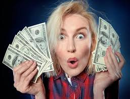 Beautiful young blonde is a lucky winner, she is holding a pile of money,  she is