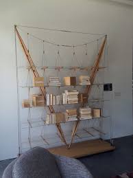 A tabletop is integrated in a shelving system, the ladder leading up to the loft bed also functions as a clothes stand, and the bed itself is a partition for the room. Cool Bookshelves Of All Kinds Enhance Home Decor
