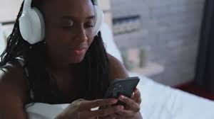 Cute dark-skinned woman listening to music