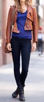 Woman On The Street Wearing Dark Blue Skinny Jeans Blue Top Brown Leather Jacket And Black Ankle Boots With A Brown Sling Bag Street Style Style Fashion