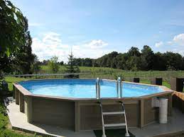 piscina decagonal alongada naturalis 03 em betao com estrutura exterior com aspeto de madeira piscinasemienterrada nat piscine beton piscine ovale piscine