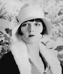 A black and white photo of a woman wearing a hat. Louise brooks actress  vintage.