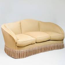 A vintage wicker settee features spring seating, a cotton seat cushion slip covered in purple fabric with decorative chenille and velvet zippered throw pillows, and a large portofino pillow. Modern Upholstered Camel Back Sofa With Fringe Sold At Auction On 25th February Bidsquare