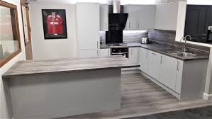 Wall colour is likely to be white (maybe with a subtle warm undertone). Kompact Slab Light Grey Gloss Kitchen Wood Effect Laminate Appliances