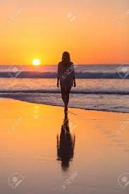 Golden sunset on the sea shore and footprints in the sand by ollirg : Woman Walking On Sandy Beach In Sunset Leaving Footprints In Stock Photo Picture And Royalty Free Image Image 54811258