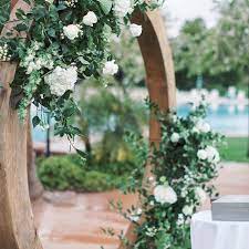 Wooden Circle Arch At Wedding Ceremony With Greenery And White Floral Arrangements By Array Wedding Ceremony Flowers White Floral Arrangements Ceremony Flowers