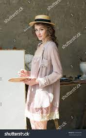 Woman Painter In Straw Hat Holding Palette With Oil Paints And Brush In Her Hands In Front Of An Empty Canvas Artist At Work Woman Painter Art Gallery Wedding