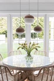 Adding a unique light above your kitchen table will enhance its appeal. Beige Wicker Chairs At Round Glass Top Table Transitional Dining Room