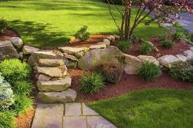 A Rock Garden With Mulch Highlights A Slope In The Front Yard Landscapefrontyardwithporch Landscaping A Slope Mulch Landscaping Landscaping With Rocks