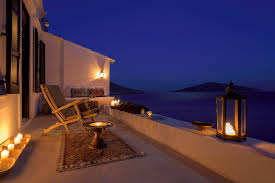 Real photo of a rattan garden furniture set with lamps and table in the background. Balcony 5 Halki Sea House
