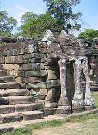 Angkor thom is right down the road from angkor wat, it's purpose was a fortified city with an impressive moat and gates to keep out invaders. Angkor Thom Wikipedia Bahasa Indonesia Ensiklopedia Bebas