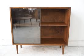 The first book shelf is a large bookshelf with adjustable bottom shelves and tapered legs. At 1st Sight New Products Vintage Mid Century Modern Sliding Glass Door Bookshelf