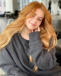 Pleased caucasian young woman puts on rubber gloves, carries two sponges, ready to wash dishes. Ariel Winter Shares Selfies Without Makeup After Turning Into A Fiery Redhead Oltnews