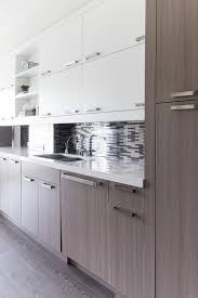 Modern Kitchen Boasts White Flat Front Upper Cabinets And Brown Oak Veneer Bottom Cabinets Adorned W Upper Kitchen Cabinets White Modern Kitchen Modern Kitchen