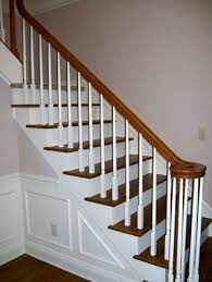 So, we decided to stain the banister and newel posts (and the wood that runs along the base of the spindles) and to paint each of the spindles a creamy white color. White Spindles With Cherry Stained Handrail Finelli Ironworks Wood Railing Wood Banister Staining Wood