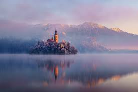 Buildings, boats, and mountains make up the stunning slovenia collection. 4587712 Lake Slovenia Lake Bled Island Castle Mountains Mist Church Reflection Landscape Wallpaper Mocah Hd Wallpapers