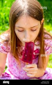 Portrait of girl eating popsicle in garden Stock Photo