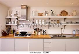 Complete kitchen unit with granite counter top, cupboards for storage and a sink. Shelves On Either Side Of Extractor Above Hob In Fitted Kitchen Unit With Stainless Steel Sink Stock Image Kitchen Kitchen Shelves Kitchen Family Rooms